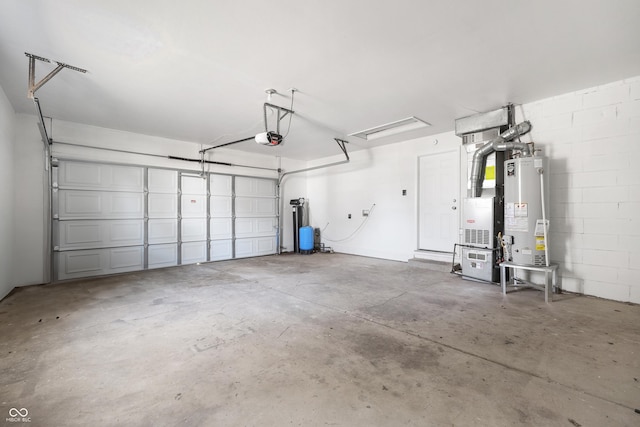 garage with heating unit, concrete block wall, a garage door opener, and water heater