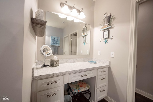 bathroom featuring visible vents, baseboards, and vanity