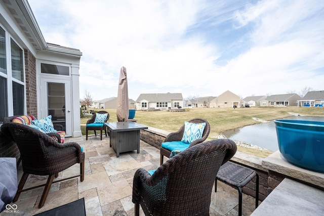 view of patio with an outdoor living space with a fire pit and a residential view