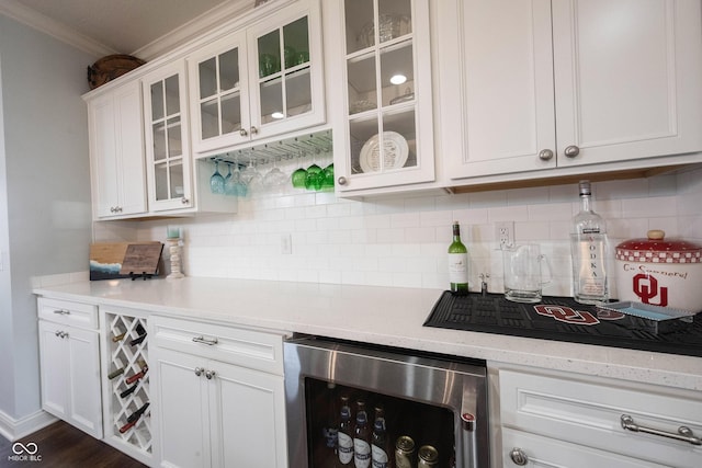 kitchen with glass insert cabinets, beverage cooler, ornamental molding, decorative backsplash, and white cabinets