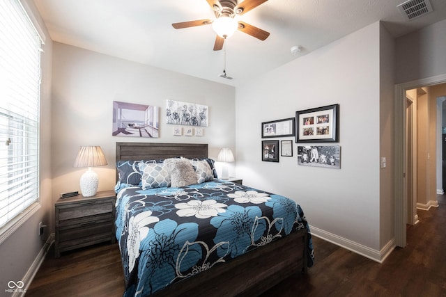 bedroom with visible vents, multiple windows, and wood finished floors