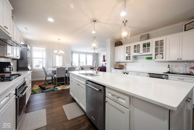 kitchen featuring crown molding, stainless steel appliances, a notable chandelier, white cabinetry, and a sink