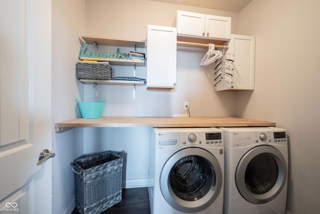 washroom featuring washer and dryer, cabinet space, and dark wood finished floors