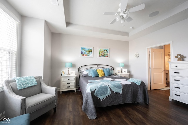 bedroom featuring a ceiling fan, a tray ceiling, and wood finished floors