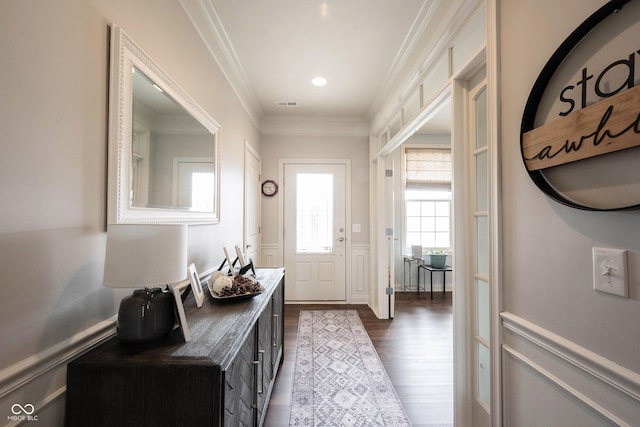 doorway to outside featuring visible vents, dark wood finished floors, ornamental molding, wainscoting, and a decorative wall