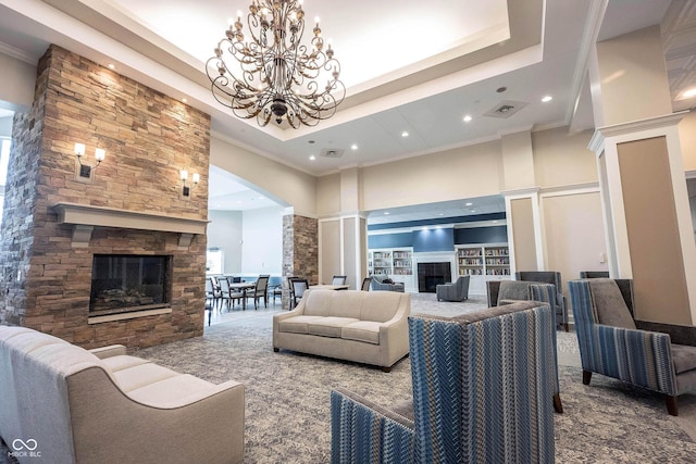 living room featuring ornamental molding, a large fireplace, a high ceiling, an inviting chandelier, and ornate columns