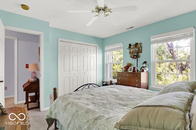 bedroom featuring visible vents, baseboards, carpet floors, a closet, and a ceiling fan