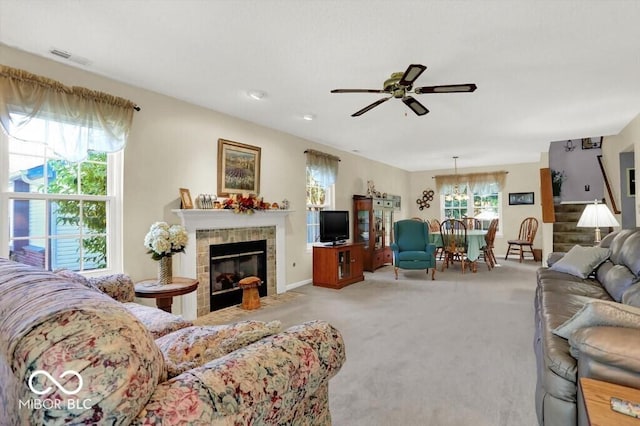 living room featuring stairway, a ceiling fan, carpet, visible vents, and a tile fireplace