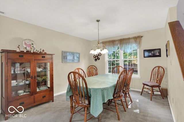 carpeted dining area featuring baseboards, visible vents, and a chandelier