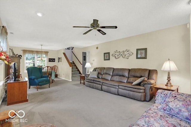 living room with stairs, carpet, and a ceiling fan