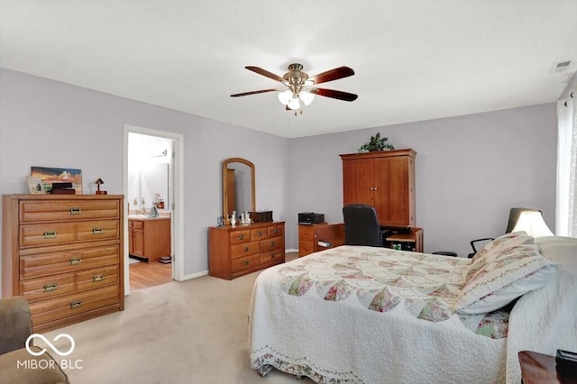 bedroom with visible vents, light carpet, a ceiling fan, ensuite bath, and baseboards