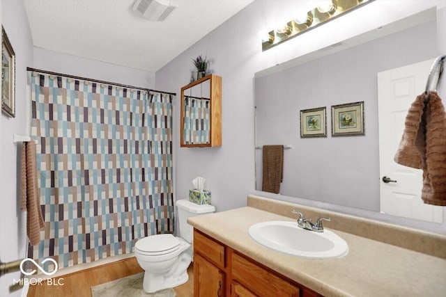 bathroom featuring visible vents, toilet, curtained shower, wood finished floors, and vanity