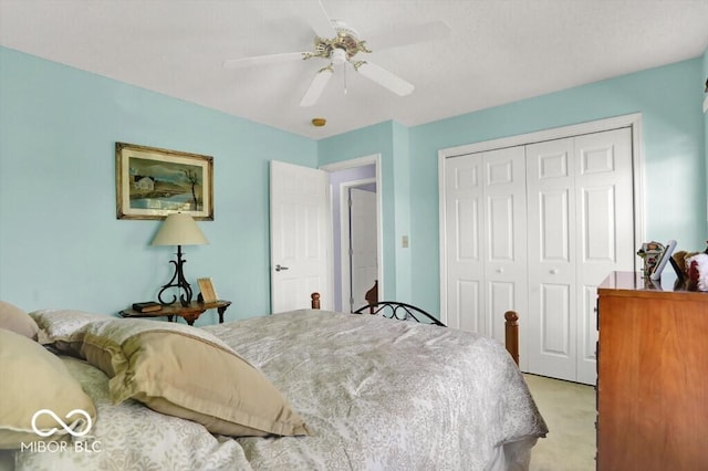 bedroom featuring a ceiling fan, a closet, and light carpet