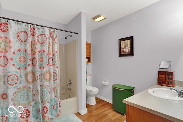 full bath with vanity, wood finished floors, baseboards, shower / tub combo, and toilet