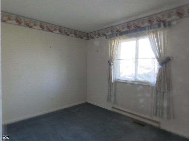 empty room featuring baseboards and a baseboard radiator