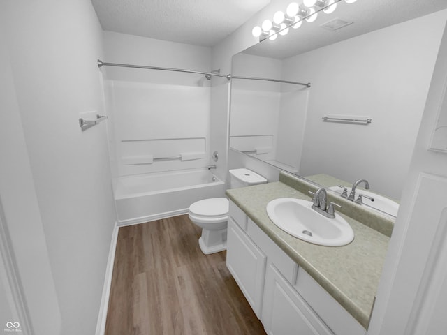 full bath with toilet, vanity, shower / bathtub combination, wood finished floors, and a textured ceiling