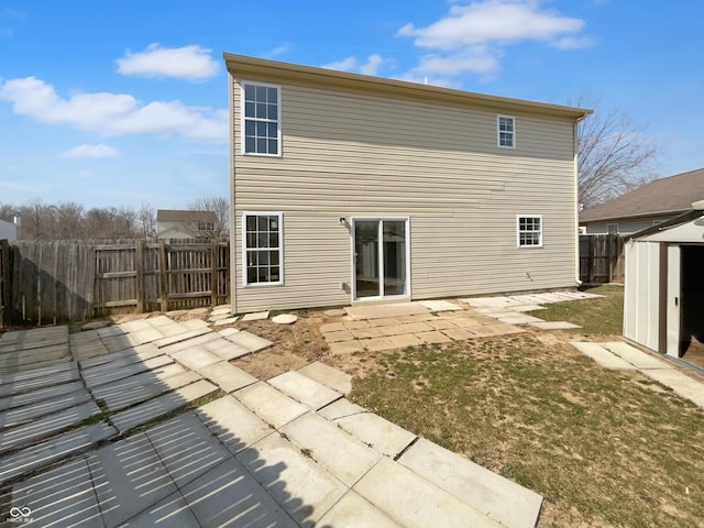 back of house with an outdoor structure, a patio area, fence, and a shed