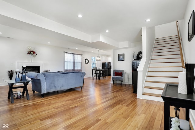 1209 N Rural St, Indianapolis, IN 46201 - living room with light wood-type flooring, recessed lighting, a fireplace, baseboards, and stairs