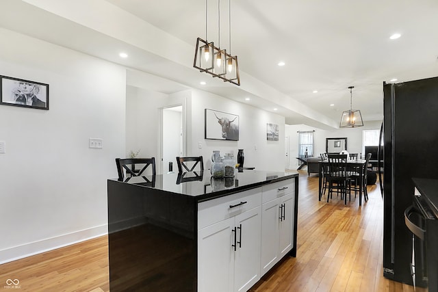 1209 N Rural St, Indianapolis, IN 46201 - kitchen featuring light wood-type flooring, dark countertops, white cabinetry, recessed lighting, and freestanding refrigerator