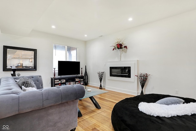 1209 N Rural St, Indianapolis, IN 46201 - living room featuring a glass covered fireplace, recessed lighting, baseboards, and light wood finished floors