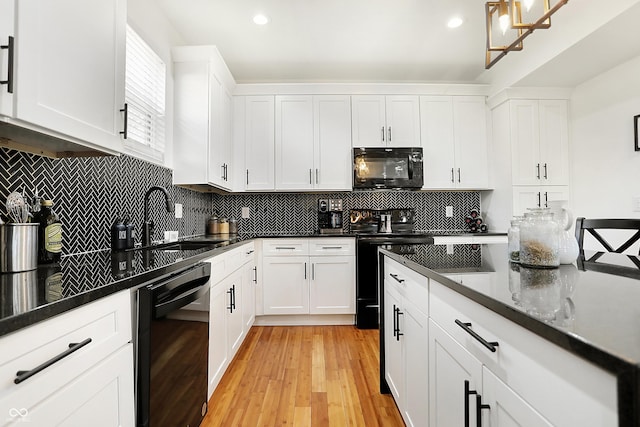 1209 N Rural St, Indianapolis, IN 46201 - kitchen with backsplash, black appliances, light wood-style floors, white cabinetry, and a sink