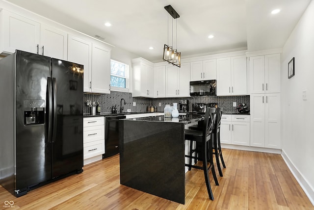 1209 N Rural St, Indianapolis, IN 46201 - kitchen featuring white cabinetry, black appliances, dark countertops, and light wood-type flooring
