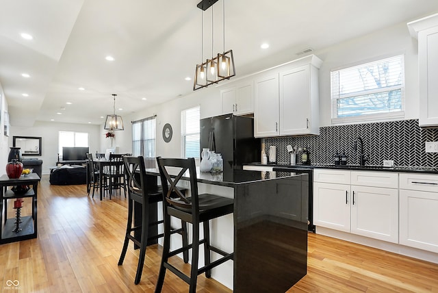 1209 N Rural St, Indianapolis, IN 46201 - kitchen with a sink, light wood finished floors, dark countertops, and freestanding refrigerator