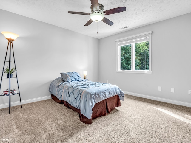 bedroom with visible vents, baseboards, a textured ceiling, and carpet flooring