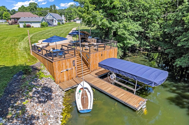 view of dock featuring a lawn and a water view