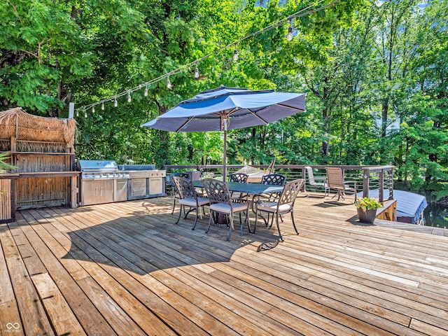 wooden terrace featuring exterior kitchen, area for grilling, and outdoor dining area