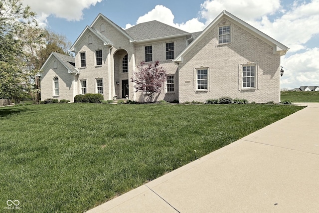 view of front of home with brick siding and a front lawn