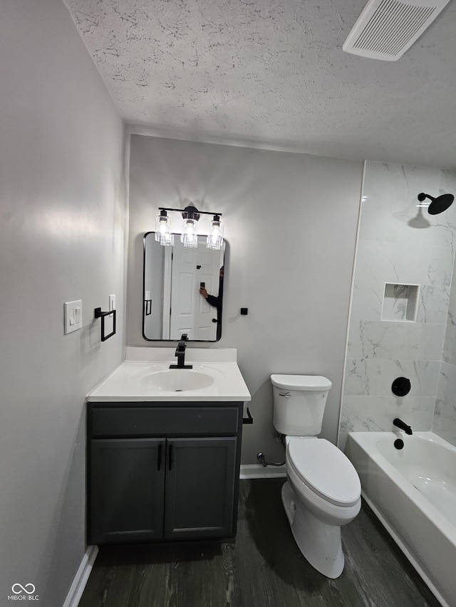 full bathroom featuring visible vents, toilet, a textured ceiling, wood finished floors, and vanity