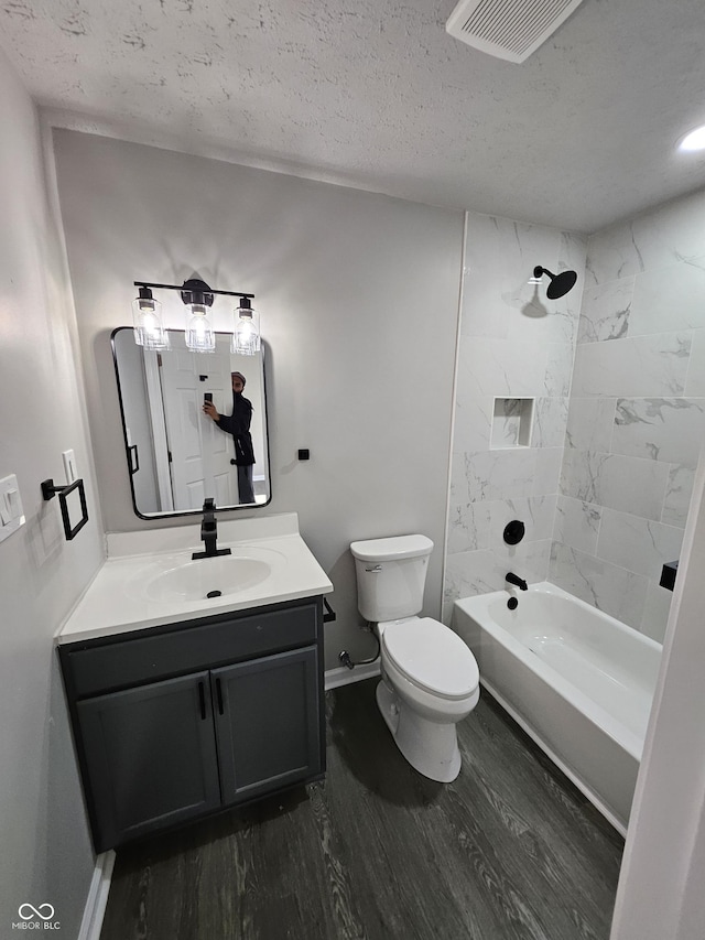 full bathroom featuring visible vents, toilet, vanity, wood finished floors, and a textured ceiling