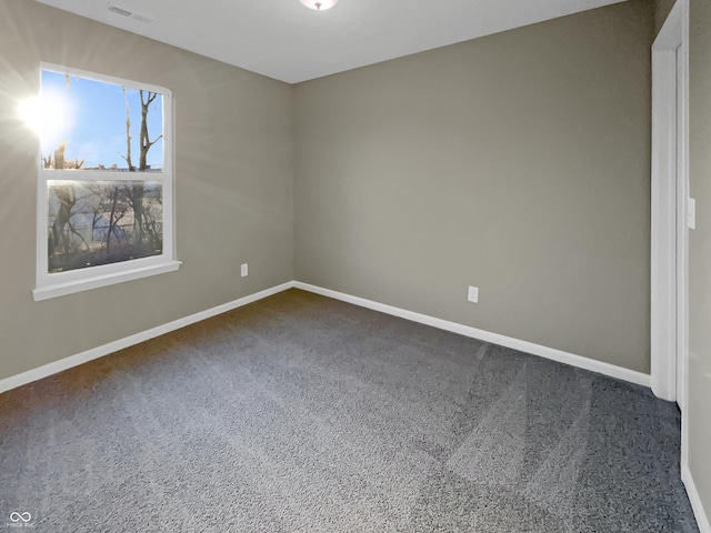 carpeted empty room featuring visible vents and baseboards