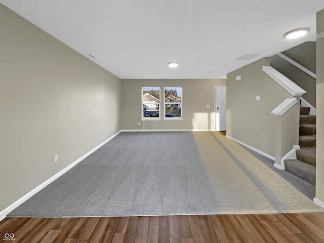 interior space with visible vents, stairway, wood finished floors, and baseboards