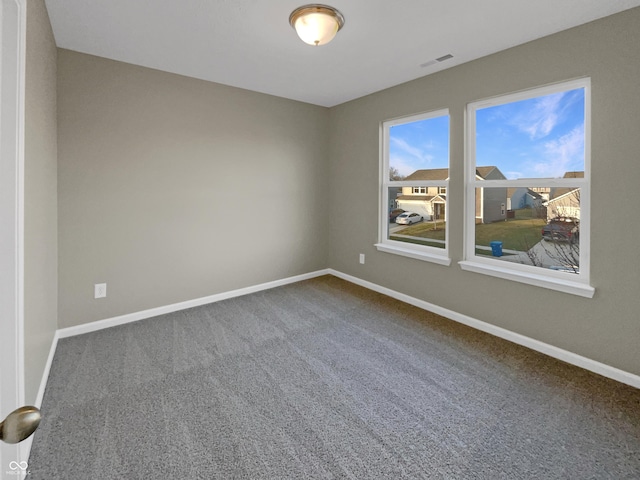 empty room featuring carpet flooring, baseboards, and visible vents