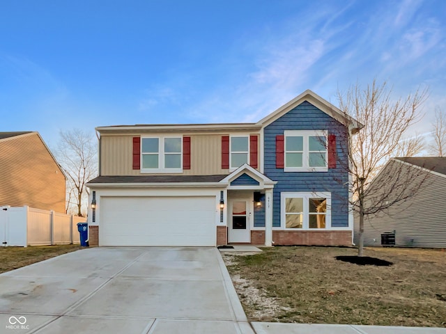 traditional-style house featuring brick siding, an attached garage, concrete driveway, and fence