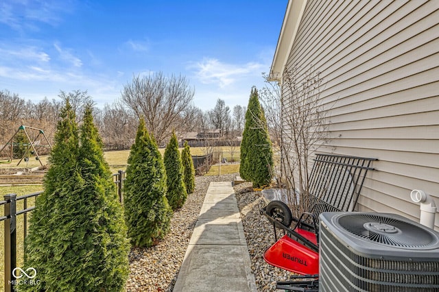 view of yard featuring fence and central AC