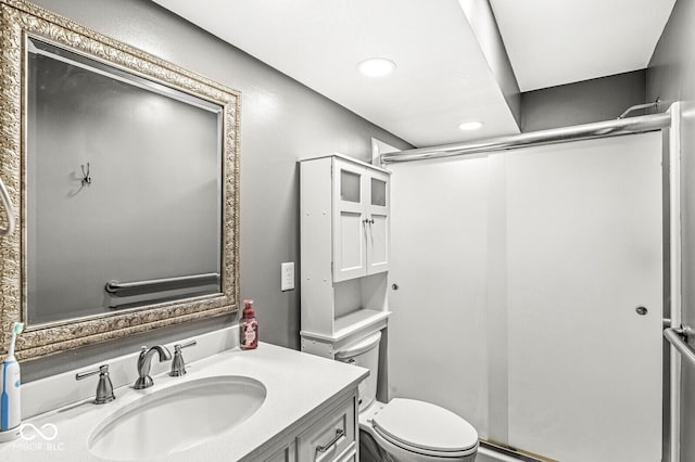 bathroom featuring recessed lighting, toilet, a stall shower, and vanity