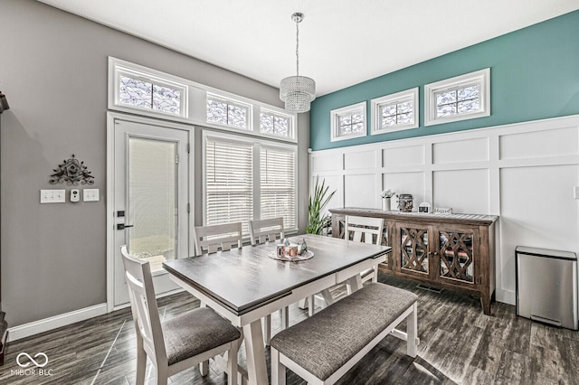 dining room featuring a decorative wall, dark wood-style floors, and a wainscoted wall