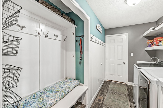 mudroom featuring dark wood-type flooring, baseboards, independent washer and dryer, and a textured ceiling