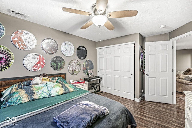 bedroom featuring visible vents, a ceiling fan, a textured ceiling, wood finished floors, and a closet