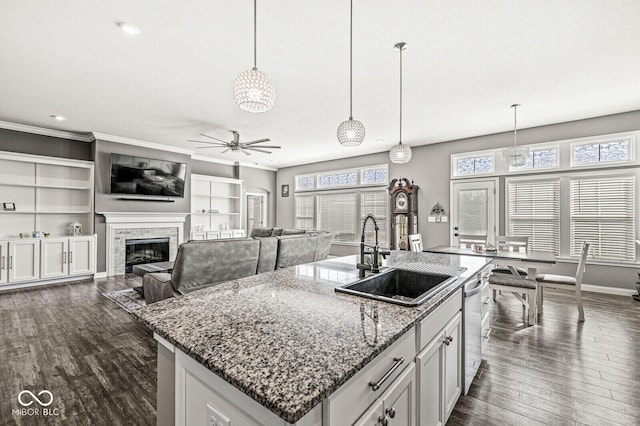 kitchen featuring a sink, a kitchen island with sink, dark wood-style flooring, and a ceiling fan