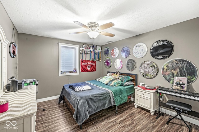 bedroom with ceiling fan, baseboards, dark wood-style flooring, and a textured ceiling