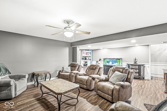 living room featuring visible vents, wood finished floors, baseboards, and ceiling fan