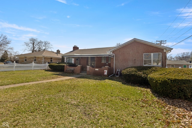 back of property with a yard, fence, brick siding, and a chimney