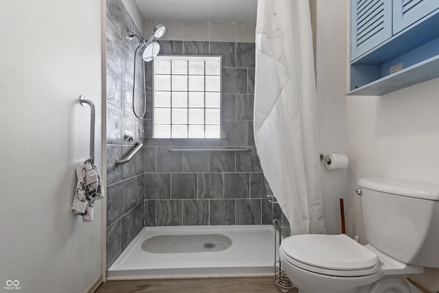 bathroom with toilet and tiled shower