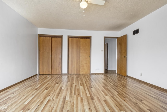 unfurnished bedroom with visible vents, a ceiling fan, a textured ceiling, light wood-style floors, and baseboards