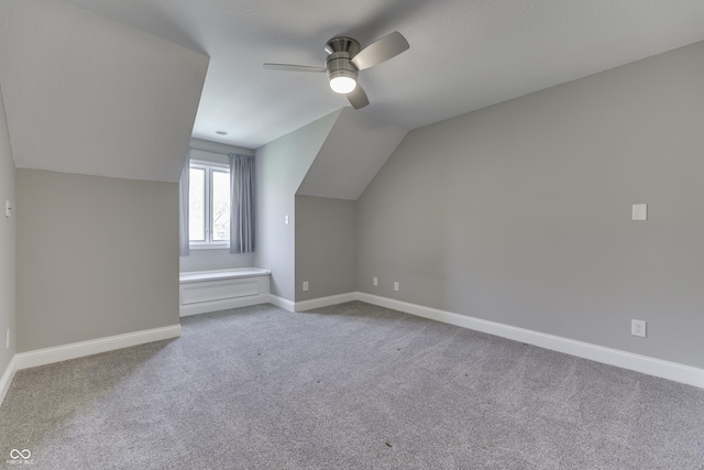 bonus room with lofted ceiling, a ceiling fan, baseboards, and carpet floors