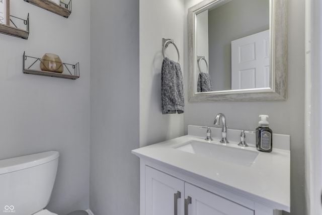 half bathroom with vanity and toilet